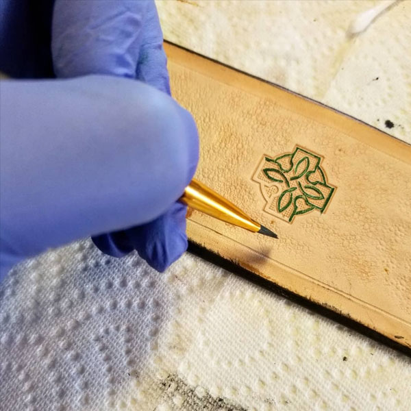 Detail photograph of dying leather belt by fine point brush
